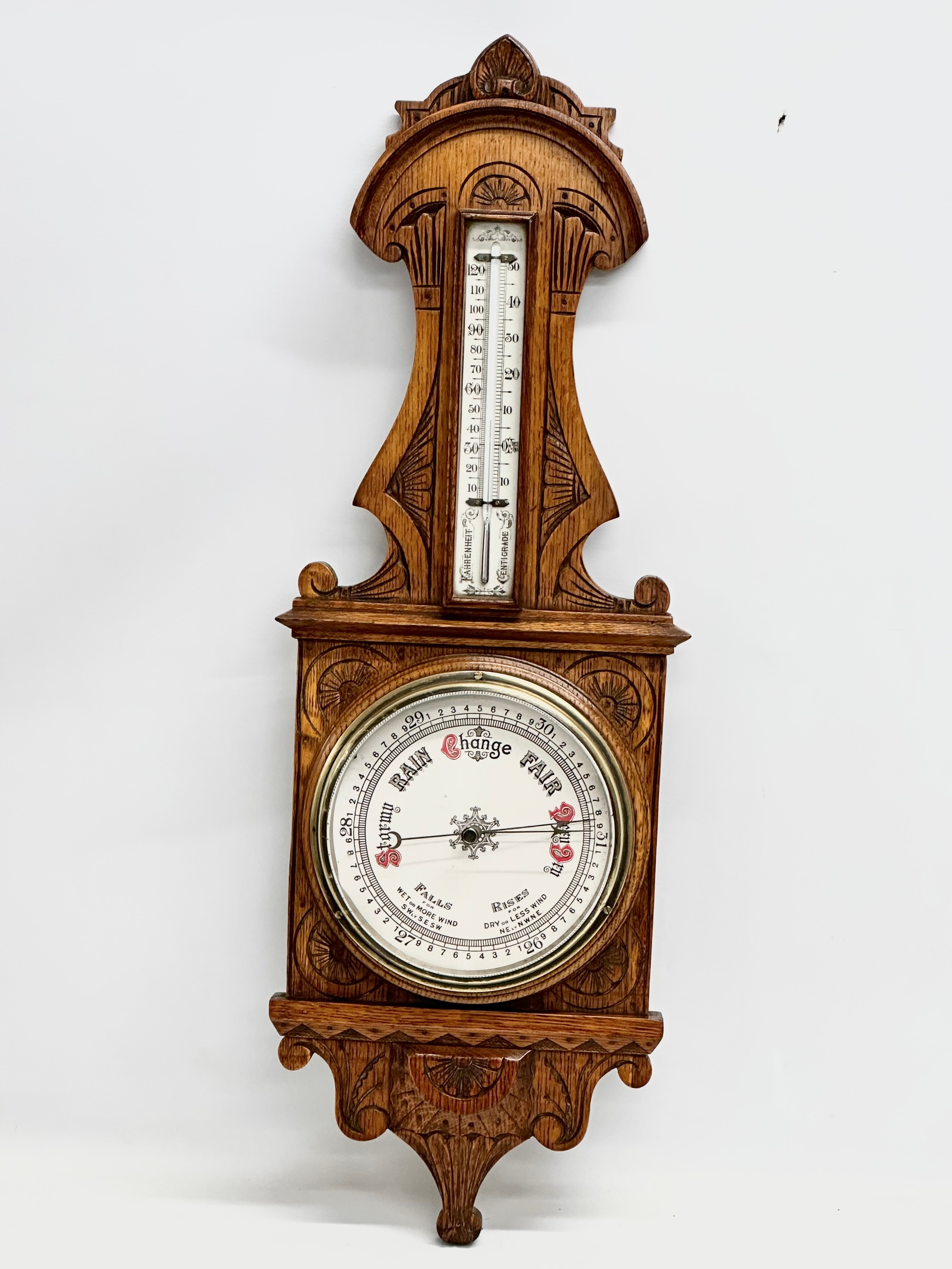 A Victorian carved oak barometer. 28x84cm W