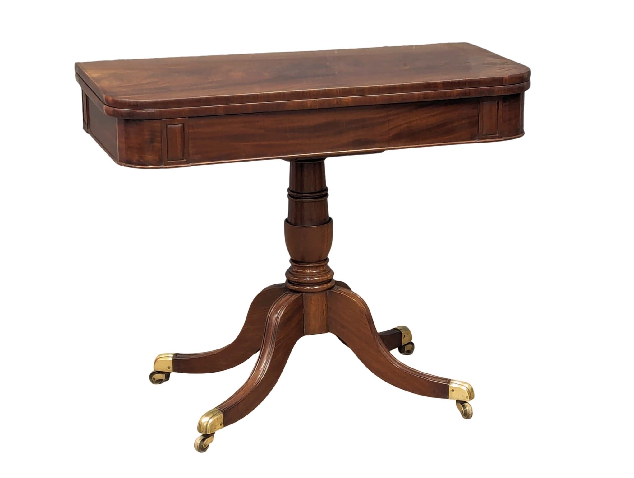 A late George III mahogany turnover games table on brass cup casters. 90.5x44.5x74.5cm