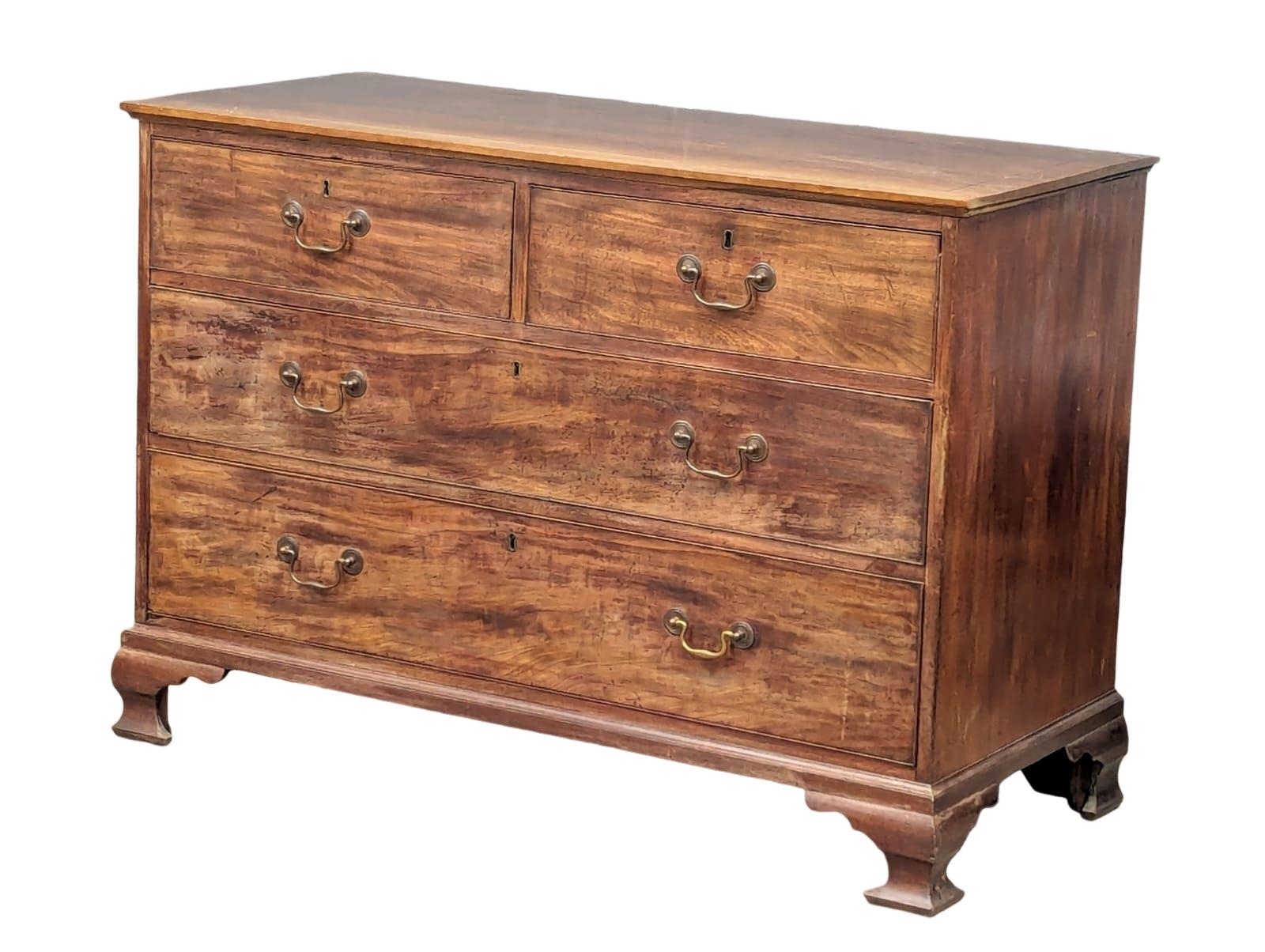 A George III mahogany oak lined chest of drawers on ogee feet and original brass drop handles. Circa