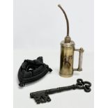 A job lot. An oil dispenser 34cm. A large ornamental key 28cm. An iron on trivet stand.