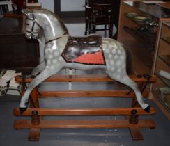 Mid 20th century freestanding rocking horse, on wooden base with metal supports, in the manner of