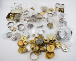 A large quantity of pocket watch parts including movements, cases, crowns, and stems. Of note