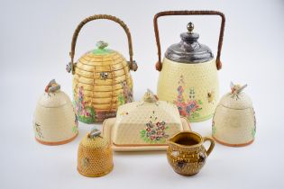 A collection of pottery honey pots and similar items in varying forms and colours to include a Royal