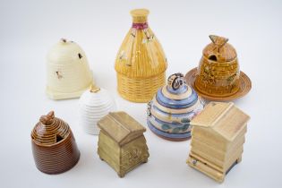 A collection of pottery honey pots in varying forms and colours to include a Beswick example, QHF,