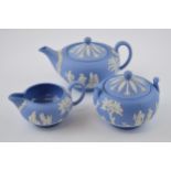 Wedgwood Jasperware in blue to include a small teapot, a milk jug and a lidded sugar jar (3).