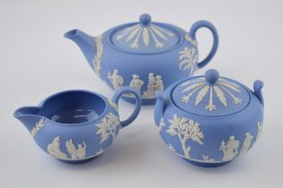 Wedgwood Jasperware in blue to include a small teapot, a milk jug and a lidded sugar jar (3).