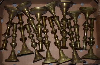 A collection of 7 pairs of brass candlesticks with ornate decoration, mostly with working pushers (