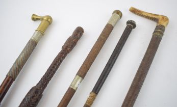 A collection of antique riding crops to include horn handled example together with brass handled and