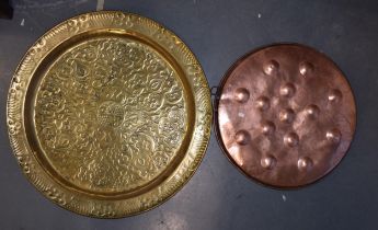 A large Eastern circular brass tray, 71cm diameter, with a smaller copper fronted tray with repousse