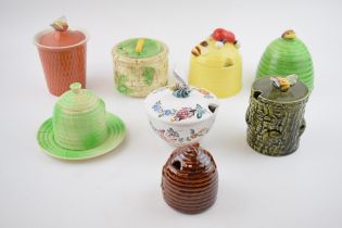 A collection of pottery honey pots in varying forms and colours to include Carlton Ware, Secla of