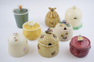 A collection of pottery honey pots in varying forms and colours to include Beswick, Crown Windsor