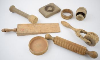 A collection of treen antique and vintage kitchenalia items to include biscuit moulds, rolling