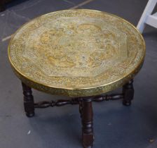 Eastern folding table with ornate brass circular top, 60cm diameter, on folding legs.