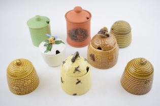 A collection of pottery honey pots in varying forms and colours to include Charmouth, Fulham Pottery