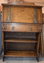 An Arts and Crafts oak students bureau with stylized metalwork, fall front, carved trefoil