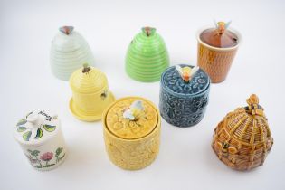 A collection of pottery honey pots in varying forms and colours to include Selca, Goebel and