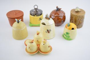 A collection of pottery honey pots in varying forms and colours to include a Carlton Ware example