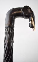 An ebony walking stick with carved elephant head handle and spirally turned design to shaft.