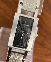 A ladies Burberry fashion watch with Swiss quartz movement. Black rectangular dial with applied