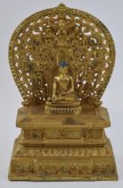 Large reproduction Tibetan gilt bronze figure of a seated Tibetan buddha on a throne, 28cm tall.