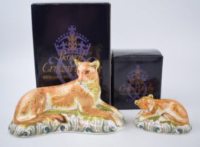 Two Royal Crown Derby paperweights, Lioness with a Sleepy Lion Cub, gold stoppers and red printed