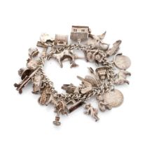 Silver charm bracelet with a collection of charms to include London Bridge, a Bobby's helmet, a