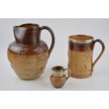 A trio of stoneware items to include a silver rimmed Doulton Lambeth tankard, a large pouring jug,