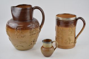 A trio of stoneware items to include a silver rimmed Doulton Lambeth tankard, a large pouring jug,