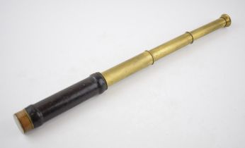 Pocket-sized brass telescope with leather grip. Brass cover to eye-piece. Inscribed 'Charles