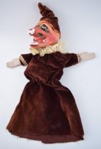 An early 20th century naive plaster hand puppet in the form of Mr Punch in velvet dress with