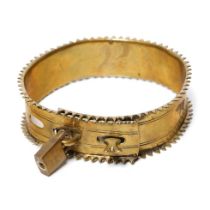 An antique brass dog collar with decorative fixings and raised spiked pattern to outer edge.