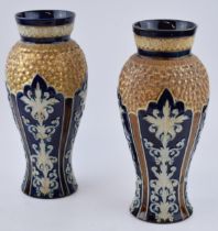 A pair of Doulton Lambeth stoneware baluster vases, white foliage on blue ground with gilt scrolls