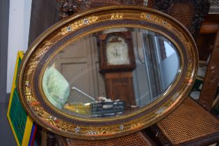 Antique decorative oval shaped mirror with oriental inlaid gilt decoration. Bevelled glass. 87cm x