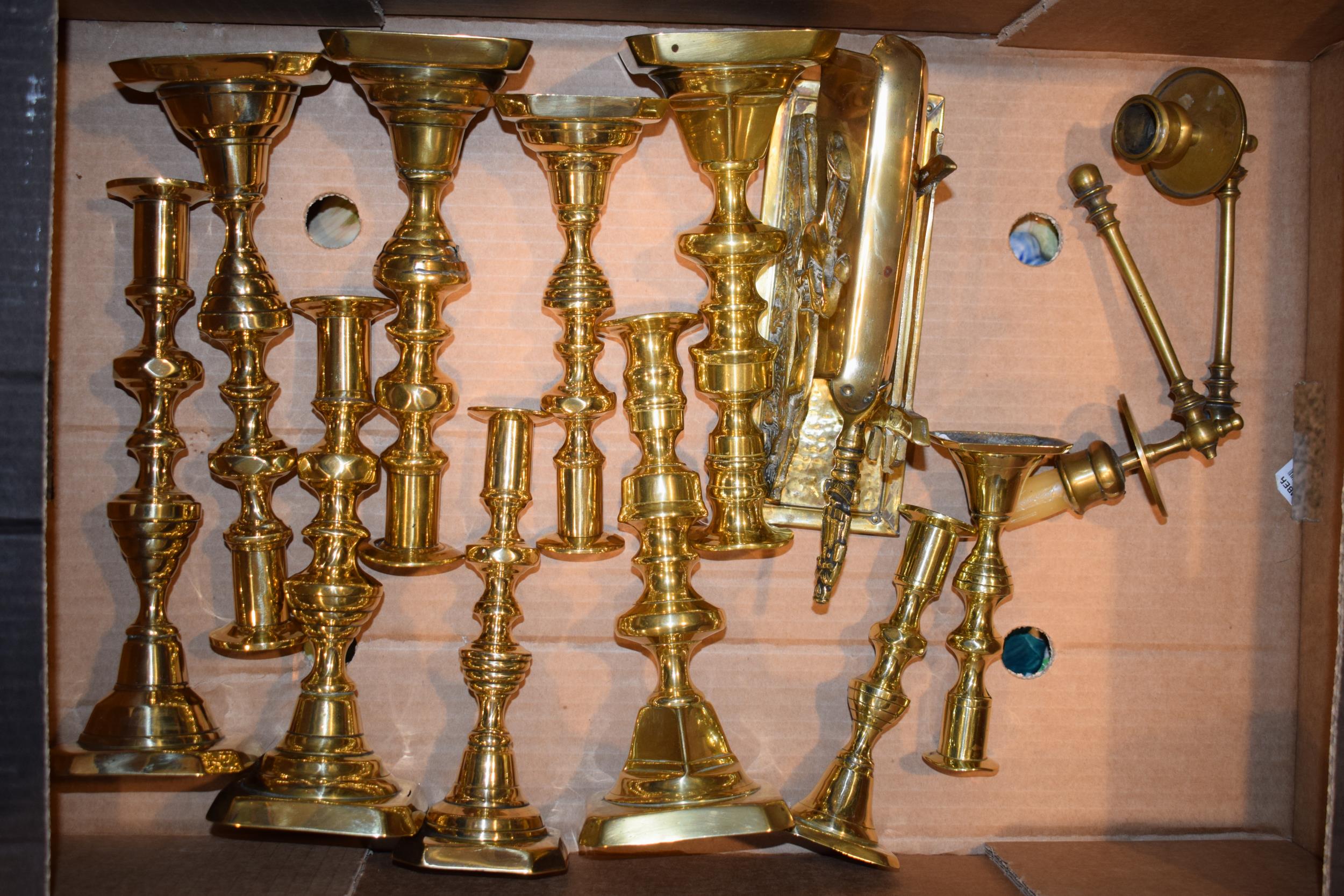 A collection of antique brass candle sticks together with other similar vintage brass items, in