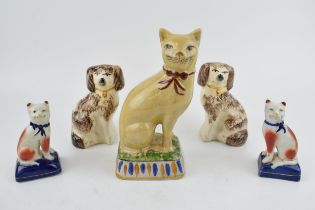 A collection of ceramic cats and dogs to include two pairs, one of Staffordshire dogs and a pair
