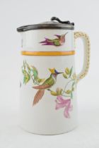 A mid to late 19th century pottery jug with hinged lid, printed and painted with hummingbirds and