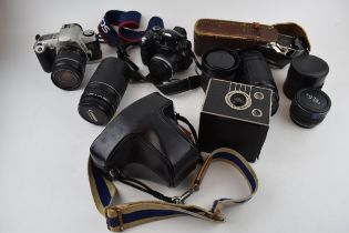 A collection of vintage cameras and lenses to include Olympus OM10, Canon EOS and FinePix cameras