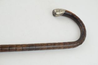 An antique walking cane with white metal handle and brass ferrel. Length 92cm. In original antique