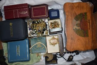 A mixed collection of costume jewellery to include brooches, a silver bangle set with amber or