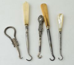 A collection of vintage button hooks to include a silver handled example, 2 bone handled items, a