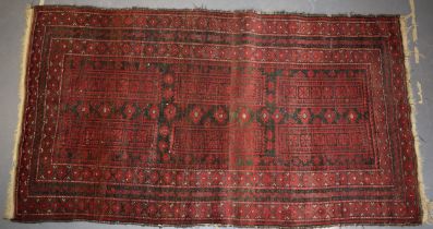 A hand-knotted oriental / middle-eastern carpet / rug in deep reds, blue and blacks. 111cm x