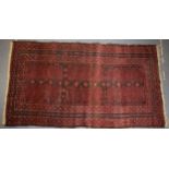 A hand-knotted oriental / middle-eastern carpet / rug in deep reds, blue and blacks. 111cm x