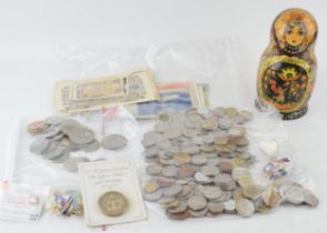 A quantity of mixed UK and Foreign currencies to include a 1977 clad Eisenhower silver dollar
