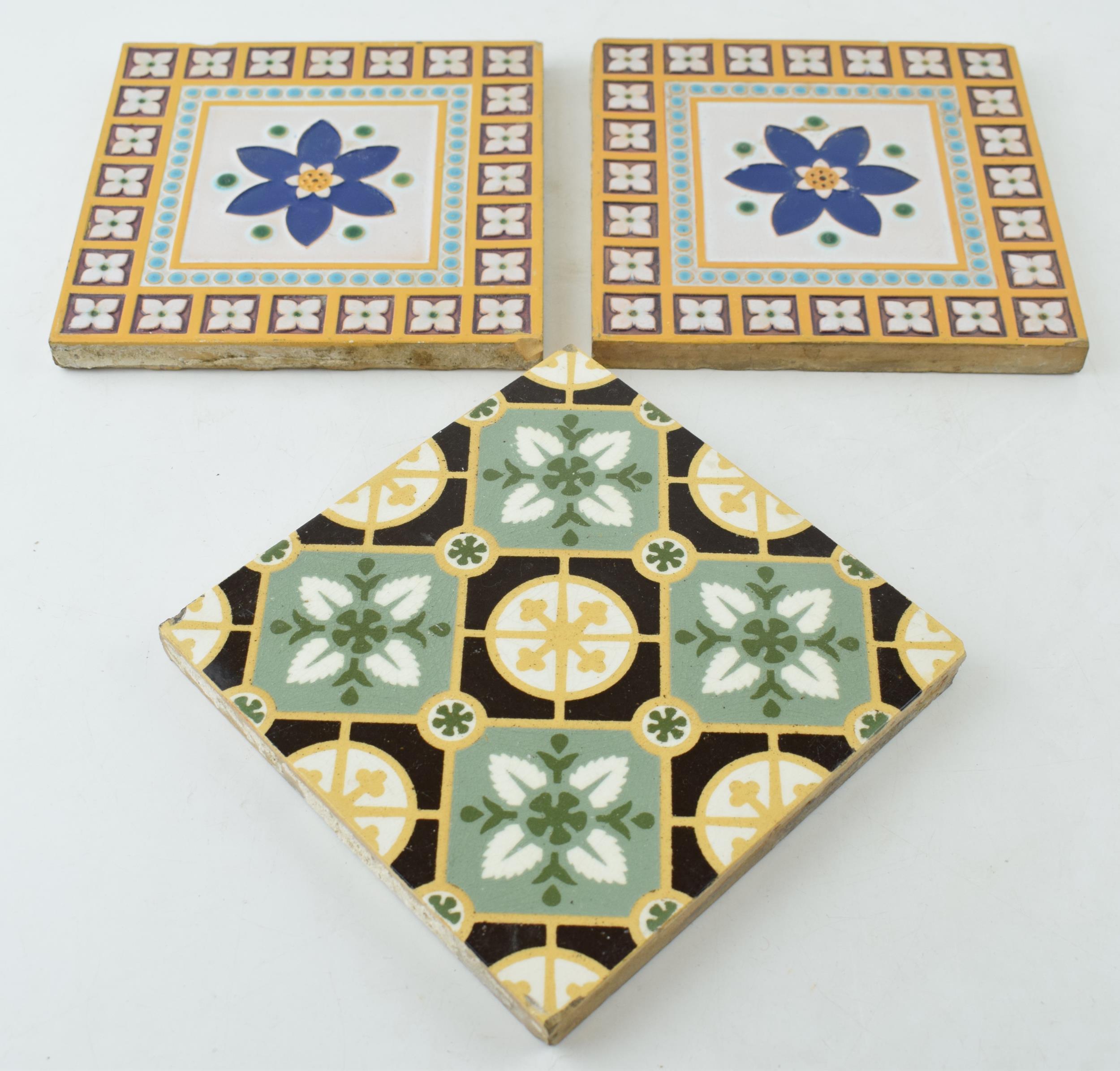 Two 6" Minton & Co, Stoke on Trent glazed tiles with central blue floral design and repeated boarder
