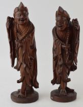 A pair of oriental smiling figures, wooden, 22.5cm tall (2).