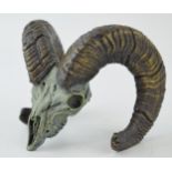 A cast metal sculpture of a rams skull and horns, signed 'F Boyer 98', 12cm wide.