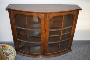 An early to mid 20th century oak bow fronted display cabinet 75cm wide, 59cm tall.