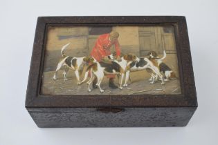 An antique cigarette tin with hand-painted scene under glass of huntsman grooming his hounds.