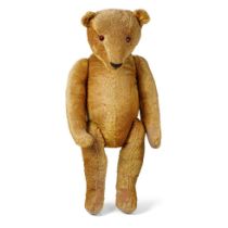 A large early 20th century straw filled teddy bear, circa 1920/30s, with jointed limbs and glass