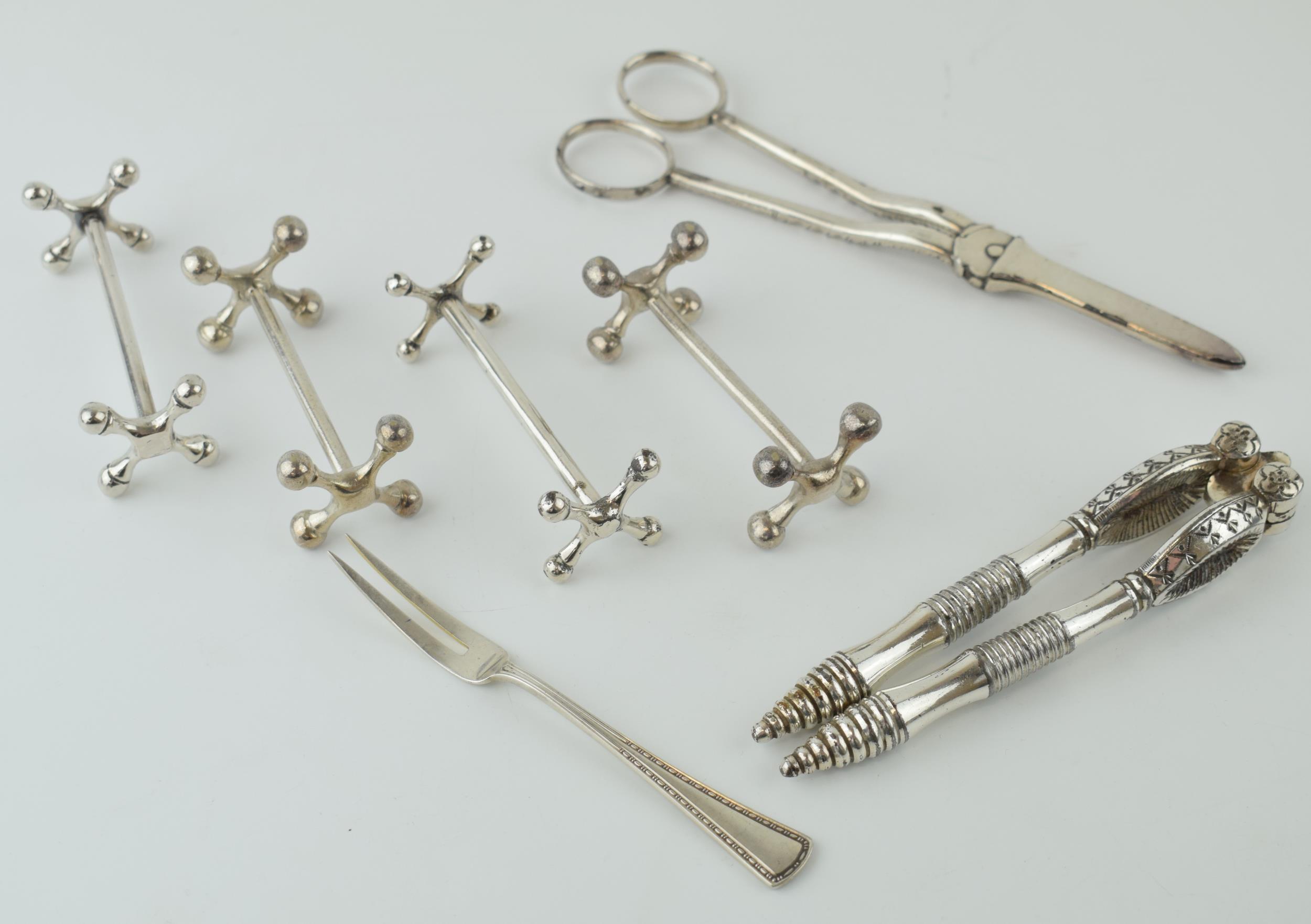A collection of silver plated items to include knife rests, a nutcracker set and others.